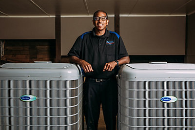 Coolray technician next to HVAC units