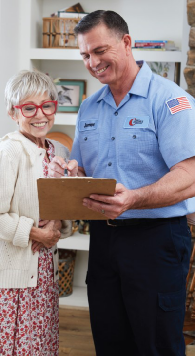 A smiling HVAC contractor assisting a customer with his clipboard.