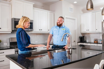 Plumber and customer talking by the sink