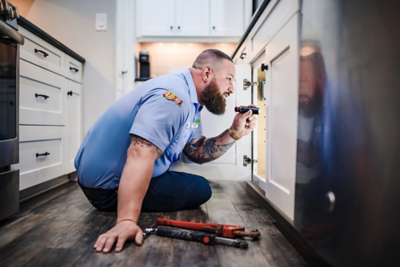 Plumber inspecting a kitchen drain