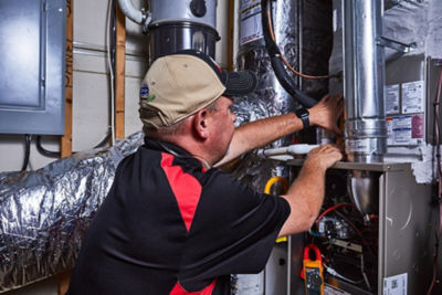 HVAC technician working on a furnace in an Atlanta area home