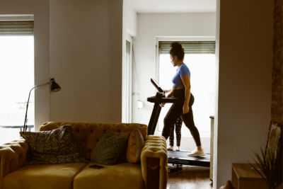 woman walking on treadmill in her home