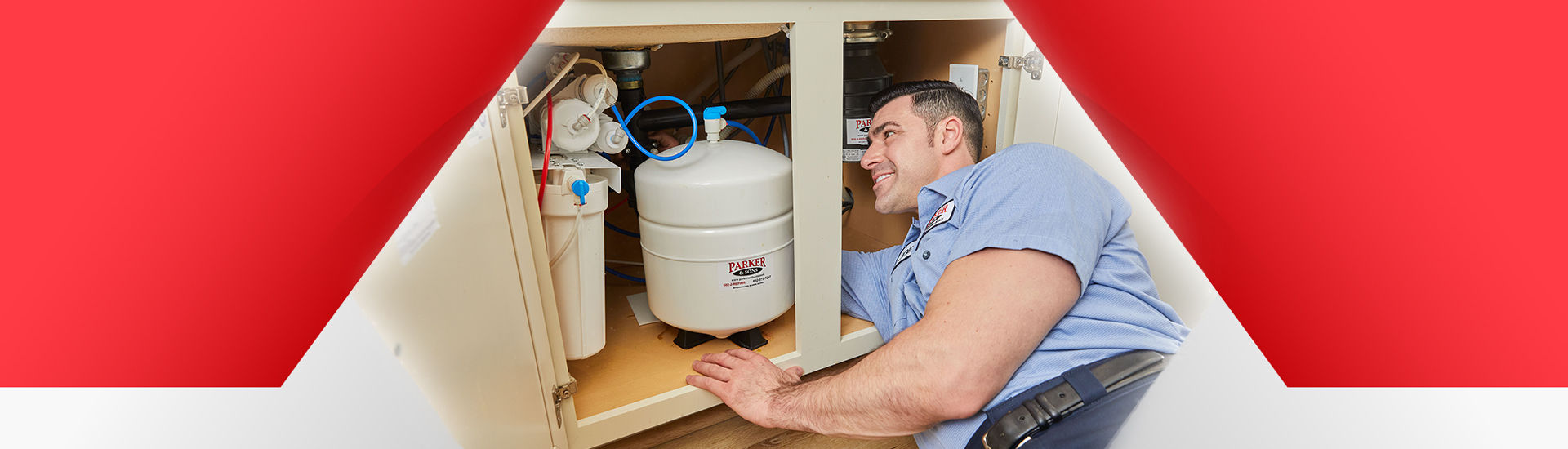 Technician working under the sink on a water softener