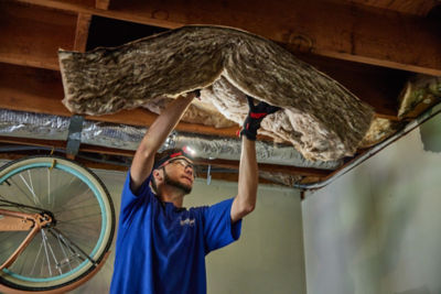 Technician removing old insulation in ceiling