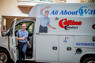 A smiling Collins technician exiting work van