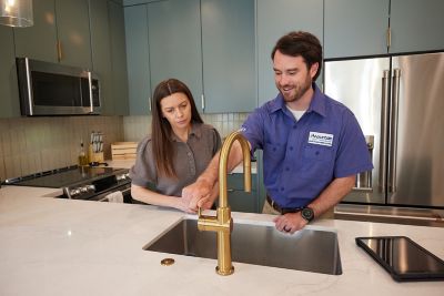 Mountain Home Services plumber showing home owner a new faucet