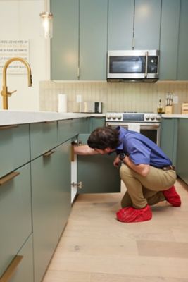 Salt Lake City plumber troubleshooting a drain problem under the sink