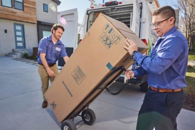 Two Plumbers in Salt Lake City taking a water heater out of their work van
