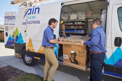 Two HVAC techs unloading Air Conditioning Unit from Work Truck 