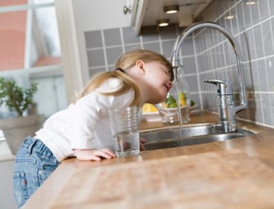 Small Girl in the kitchen drinking water