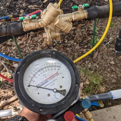 commercial backflow preventer being tested by Lindstrom plumber