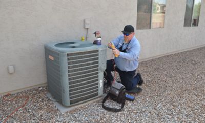 man performing maintenance on ac condenser