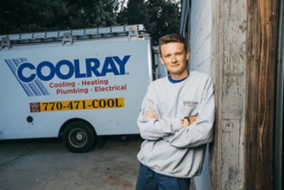 Atlanta AC Installer Leaning Against a Wall Smiling with Arms Folded