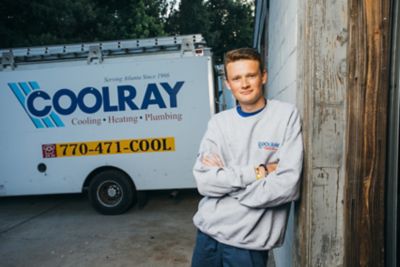 Atlanta AC Installer Leaning Against a Wall Smiling with Arms Folded