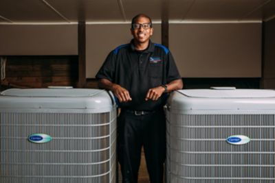 Coolray HVAC tech next to two air conditioning units