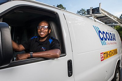 Coolray technician smiling in front of van