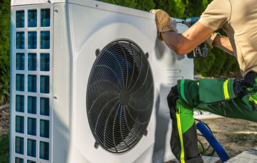 Technician working on a heat pump’s outdoor unit