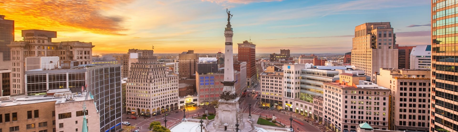 An aerial view of Indianapolis at sunset, featuring Monument Circle