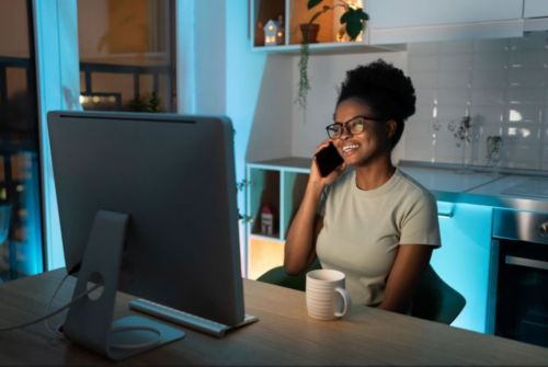 Woman sitting at her kitchen counter talking on the phone 