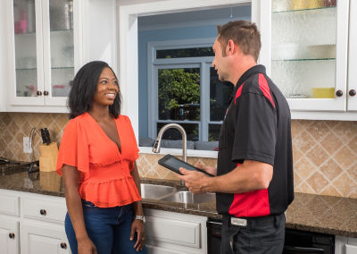 Mr. Plumber holding tablet while explaining to customer