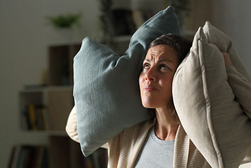 A person holding pillows on her head 