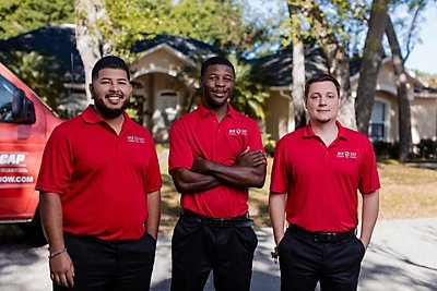 Three smiling Red Cap technicians