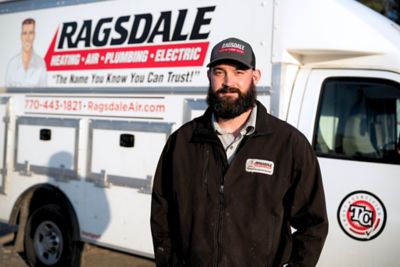 HVAC technician in front on Ragsdale work truck