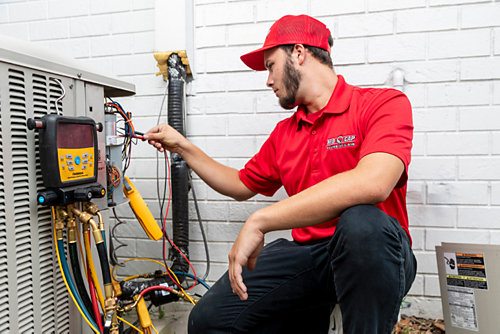 A Red Cap technician checking an exterior electrical system