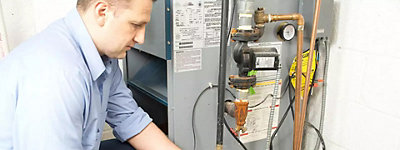 Technician fixing a gas furnace - Jarboe's Plumbing, Heating, and Cooling