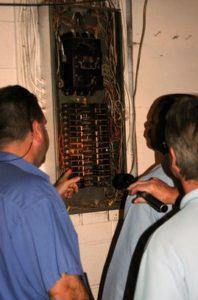 Three guys inspecting an electrical panel