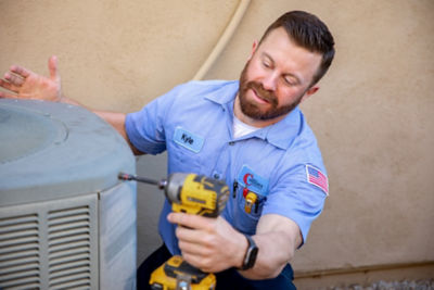 Technician Kyle Drilling the Lid on a Newly Installed AC Unit in Phoenix