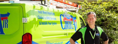 Smiling technician standing in front of Williams Comfort Air truck - Williams Comfort Air Heating, Cooling, Plumbing & More