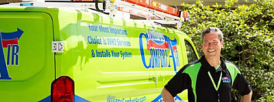 Smiling technician standing in front of Williams Comfort Air truck - Williams Comfort Air Heating, Cooling, Plumbing & More