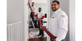 Three techs smiling and cleaning out a dirty air duct