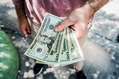 man holding money while discussing AC bill