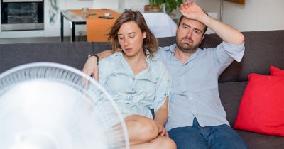 Stressed couple trying to refresh from summer heatwave