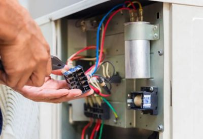 A man repairing an AC contactor.