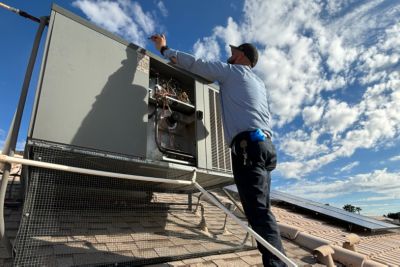 HVAC technician installing air conditioning float safety switch