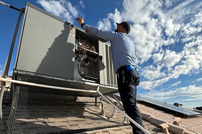 HVAC technician installing air conditioning float safety switch