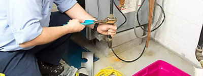 Technician fixing a gas furnace - Williams Comfort Air Heating, Cooling, Plumbing & More