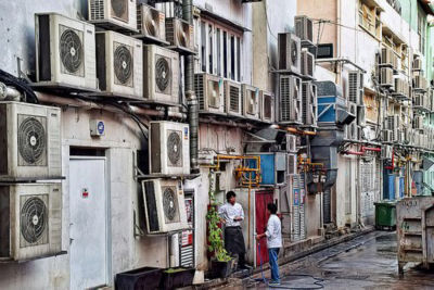 Multiple AC units stuck to the walls of a street