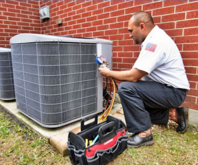 Tech inspecting an air conditioning unit