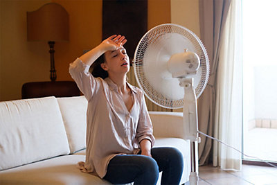 A woman sitting in front of a fan