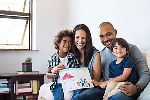 Smiling family holding kid's drawing