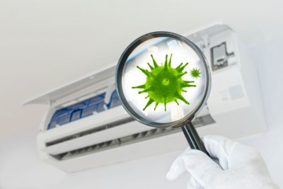 Magnifying glass showing germs coming from AC