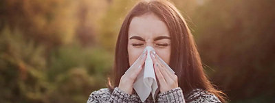 Woman sneezing in autumn because of fall allergies - Williams Comfort Air Heating, Cooling, Plumbing & More