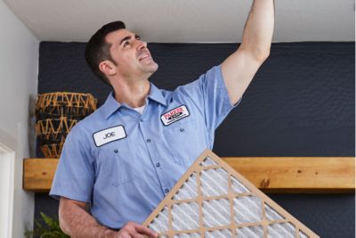 HVAC tech changing an air filter in the ceiling 