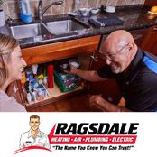 An Alpharetta homeowner talking to a plumber from Ragsdale next to a kitchen sink drain.