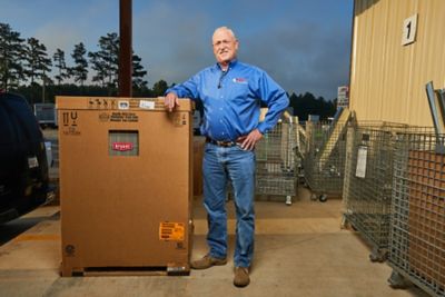 Art Ragsdale standing next to a new HVAC system