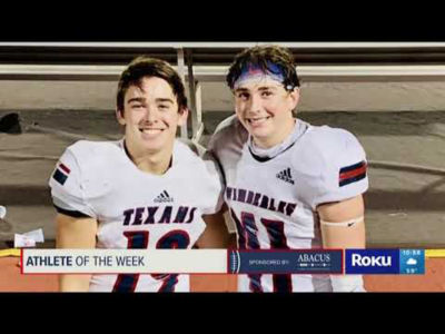 Two smiling football players standing next to each other.